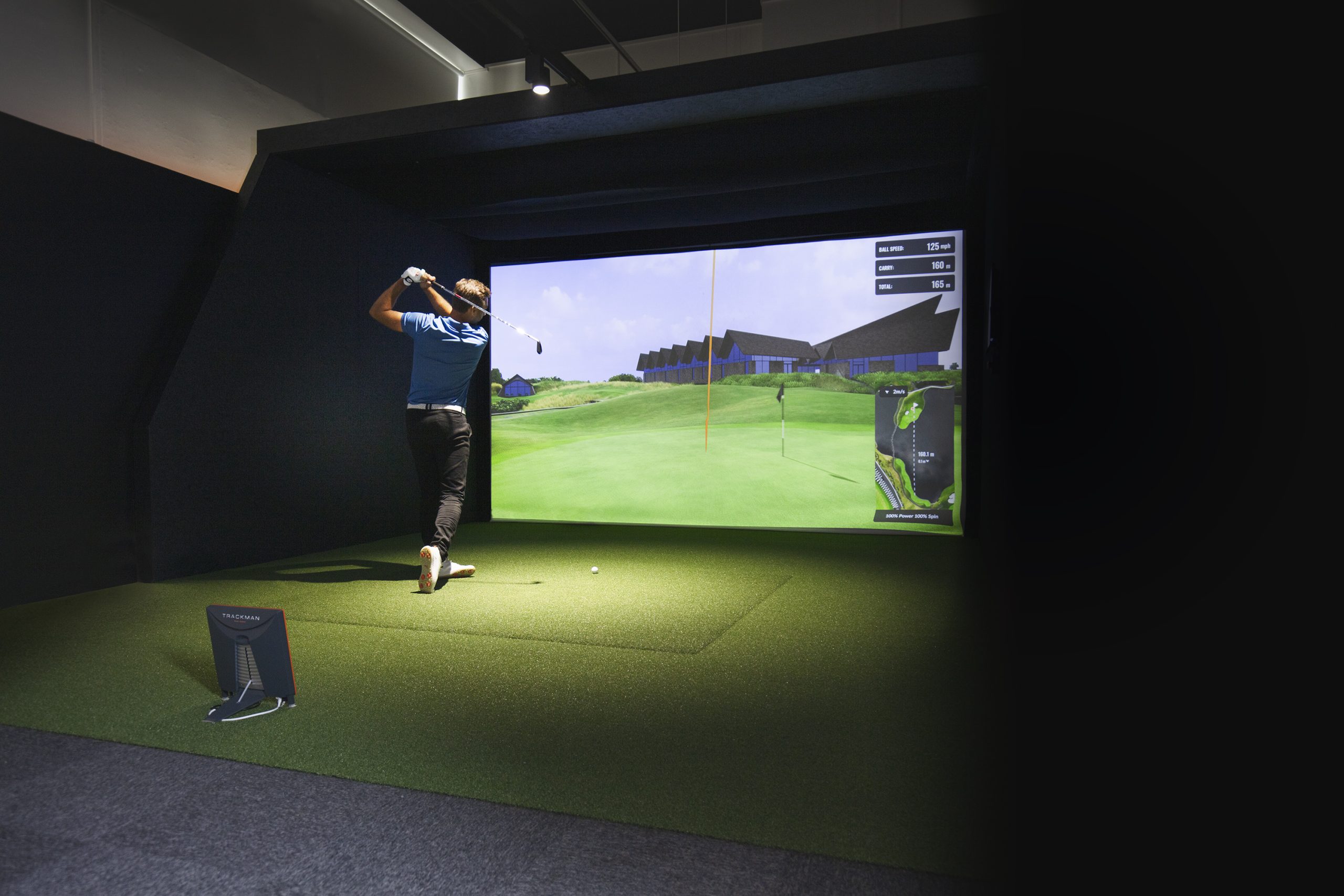 Jacob Sjöman using the golf simulator to practice his swing.