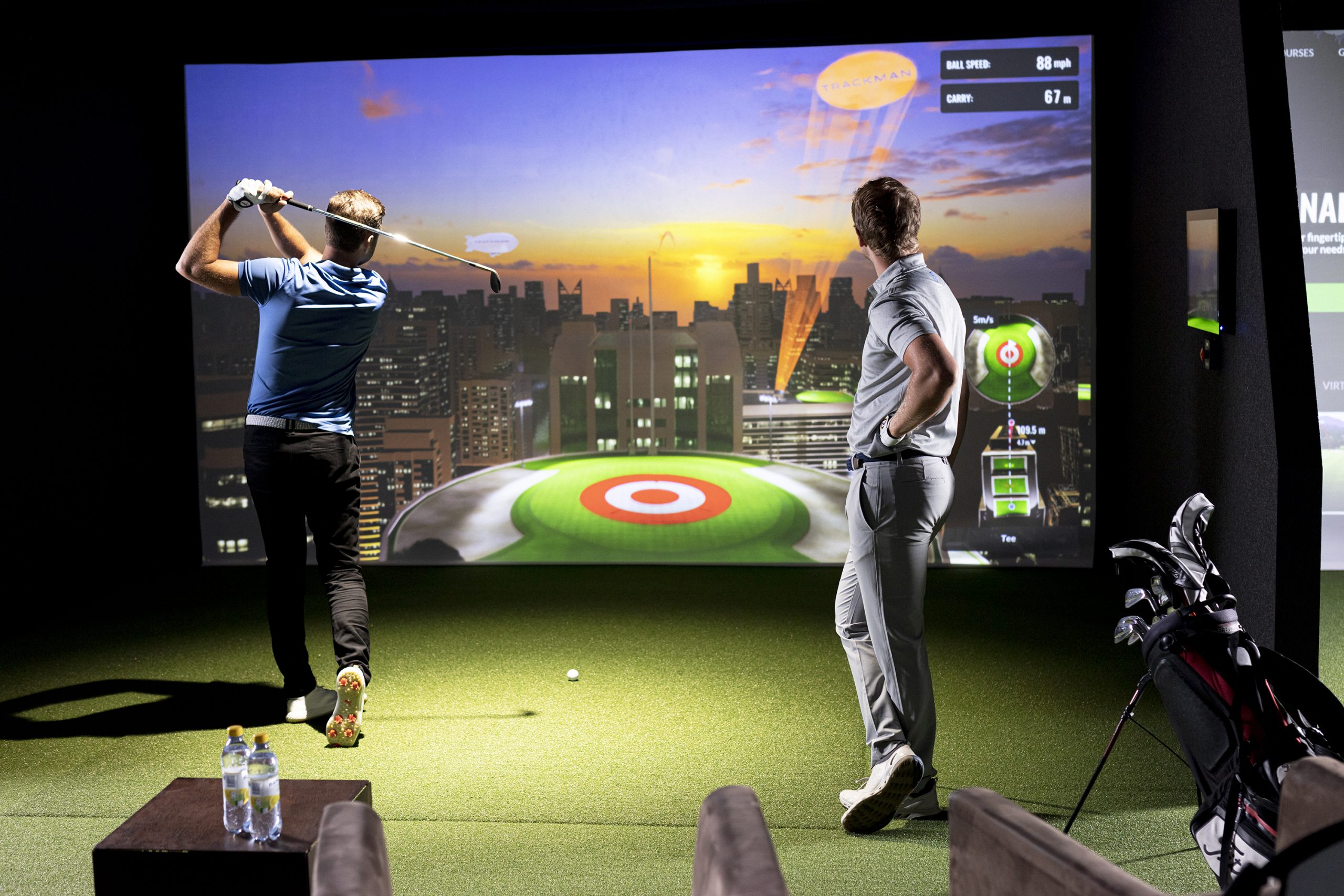 Two golfers using the golf simulator at Indoor Tee.